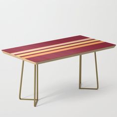 a red and yellow striped table sitting on top of a white floor