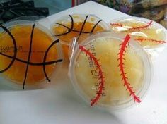 two plastic bags filled with oranges sitting on top of a counter next to a basketball