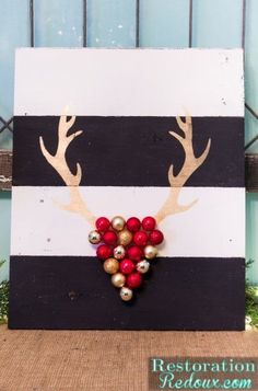 a wooden sign with reindeer antlers and ornaments on it