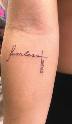 a woman's arm with the word fearless tattooed on her left side calf area