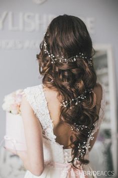 the back of a bride's head with flowers and pearls in her wedding hair