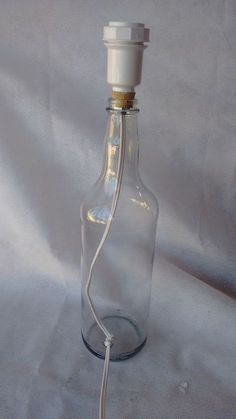 an empty glass bottle with a white cord attached to the top is shown on a white background