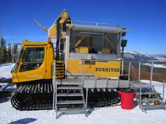 a yellow bulldozer sitting on top of snow covered ground