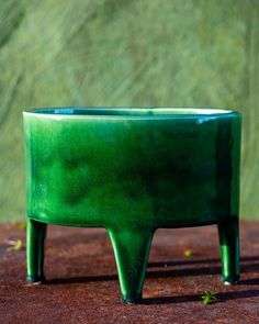 a green planter sitting on top of a wooden table