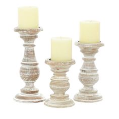 three white candles sitting next to each other