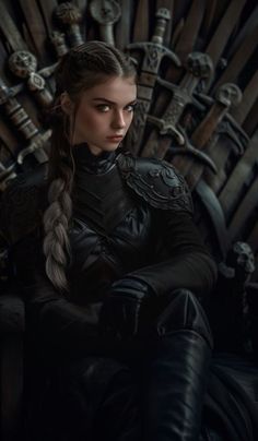 a woman sitting on the iron throne with her arms crossed and looking at the camera