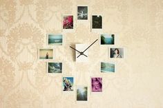 a clock that is on the side of a wall with pictures hanging from it's sides