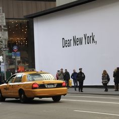 a taxi cab is driving down the street in front of a new york department store