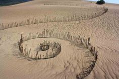 an odd shape made out of sticks in the sand