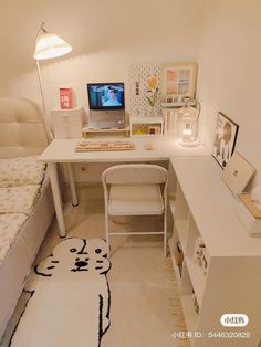 a bedroom with a bed, desk and computer on top of the dresser next to it