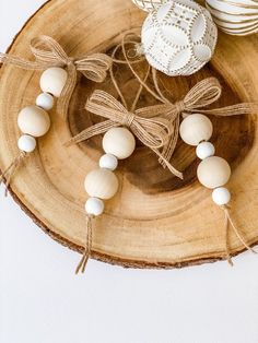 some white beads are sitting on a wooden plate with twine and lace around them