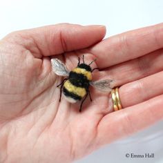 a tiny bee sitting on top of someone's hand