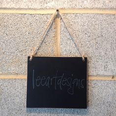 a sign hanging on the side of a building that says leeardesigns