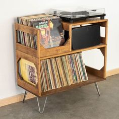 an old record player sits on top of a wooden shelf with records and vinyls