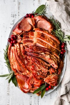 a platter filled with meat and cranberries on top of a white table