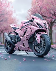 a pink motorcycle is parked on the street in front of some trees with pink flowers