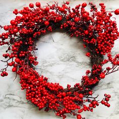 a red berry wreath on a marble surface