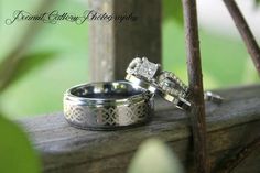 two wedding rings sitting on top of a tree branch next to each other with their matching bands