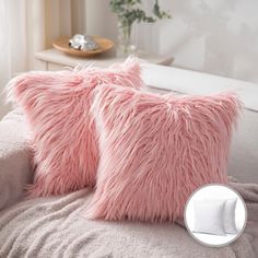 two fluffy pink pillows sitting on top of a couch