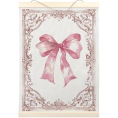 a pink bow on a white wall hanging from a wooden frame with an ornate border