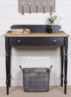 a wooden table with a metal basket underneath it and an old fashioned faucet