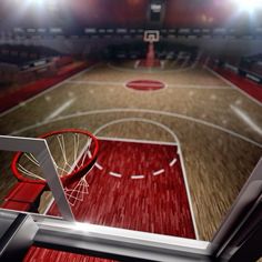 an indoor basketball court with red and white lines on the floor, surrounded by bright lights