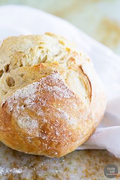 a loaf of bread sitting on top of a white paper towel covered in powdered sugar