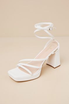 Complete your OOTN to perfection with a little help from the Lulus Antonnia White Strappy High Heel Ankle Wrap Sandals! Smooth faux leather shapes these iconic heels that feature a square footbed and a strappy, asymmetrical upper (all atop a 0.75"" toe platform). Long slender straps sprout from the sides to wrap around the ankle and secure with a silver buckle. A sculpted, sky-high block heel completes the look! 3. 75" wrapped block heel. Lightly cushioned insole. Rubber sole has nonskid marking White Heels For Wedding, White Sandal Heel, Iconic Heels, White Strappy High Heels, Graduation Shoes, Hoco Inspo, Strapped Heels