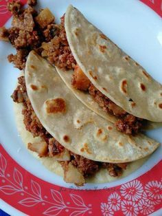 three tortillas on a red and white plate