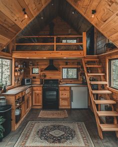 the interior of a tiny cabin with stairs leading up to an upper level kitchen area