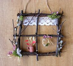 a wooden frame with branches and flowers on it