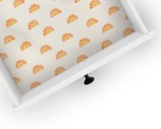 an orange and white wallpaper with fan design on it's side, under a shelf