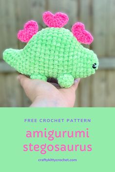 a green crocheted stuffed animal with pink ears