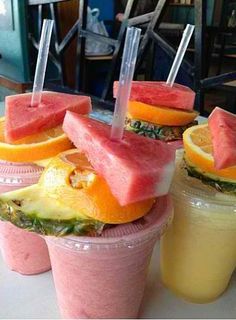 three cups filled with different types of fruit on top of each other and straws sticking out of them