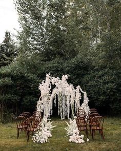 an outdoor ceremony setup with white flowers and chairs