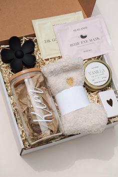 an open box with some items in it on a white table and a black flower