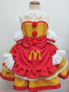 Transform your little one into a delightful Ronald clown with our Colorful MC Clown Costume Dress for Girls. Available in sizes from 1 to 12 years, this charming outfit is perfect for parties, halloween, performances, and imaginative play. 🎉👧 The dress features a full skirt with two layers: a longer yellow bottom layer trimmed in red, and a shorter yellow top layer edged with white lace. The dress also includes white, off-the-shoulder puffed sleeves adorned with red ribbon trim, in heart-shape Clown Wedding Dress, Clown Girl Outfit, Clown Outfit Ideas, Ronald Mcdonald Costume, Clown Outfits, Angel And Devil Costume, Clown Dress, Red Pom Poms, Magical Girl Outfit