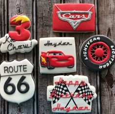 decorated cookies with cars and road signs on top of a wooden table next to a sign that says route 66