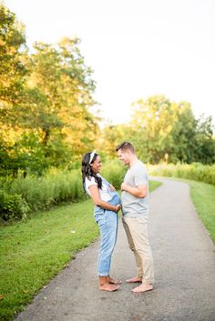 an engaged couple standing in the middle of a path