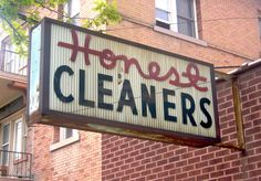 a sign that says house cleaners hanging from the side of a red brick building