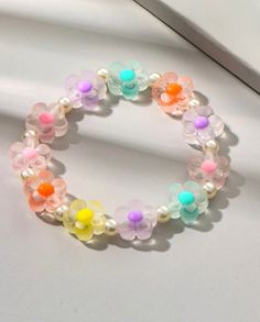 the bracelet is decorated with multicolored beads and flowers on it's side