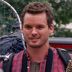 a man holding a tennis racquet in his right hand and looking at the camera