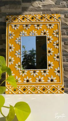 a yellow and white mirror sitting on top of a table