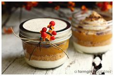 two jars filled with dessert sitting on top of a table