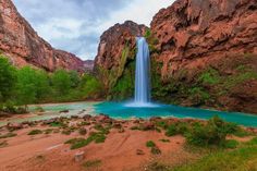 a large waterfall in the middle of a canyon