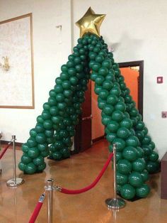 an inflatable christmas tree is on display at the entrance to a room with red carpet