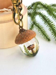 a keychain with an acorn inside of it on top of a table