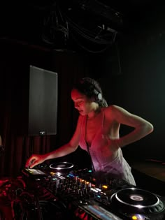 a woman in white dress mixing music on a turntable