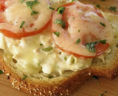 an open face sandwich topped with shrimp and tomatoes