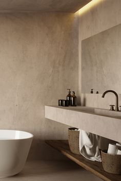 a white bath tub sitting on top of a bathroom floor next to a sink and mirror